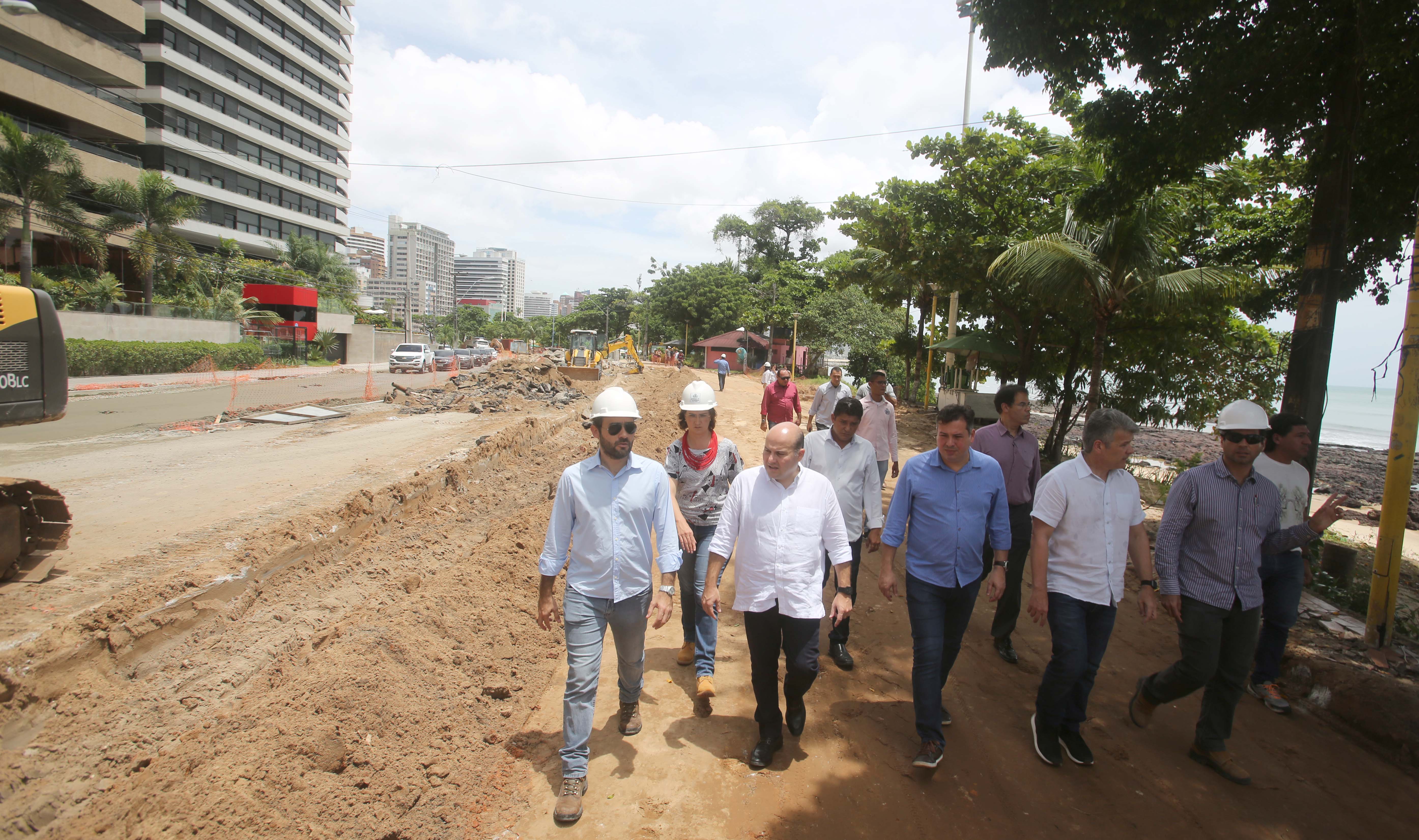 um grupo de pessoas caminha no canteiro de obras da nova avenida beira-mar